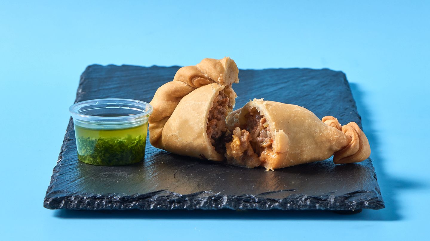 Aufgeschnittene Empanada mit Chimichurri